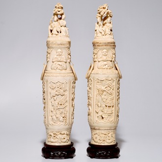 A pair of tall Chinese ivory vases and covers on wooden base, early 20th C.